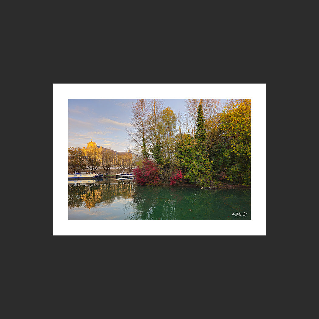 Photographie des rives colorées du canal de la Marne à Châlons-en-Champagne avec la cathédrale et les péniches à quai en automne au soleil couchant, Champagne, Marne, Grand Est, France.